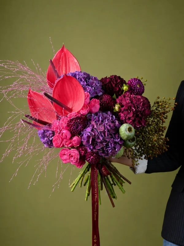Buchet dramatic cu anthurium roșu-corai, hortensii mov, dalii vișinii și panicum roz
